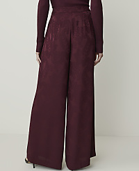 A person stands in wide-leg burgundy pants with a paisley pattern in the foreground, against a plain white background. carousel Product Image 3