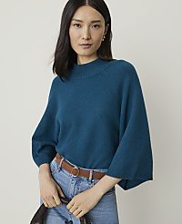 A woman in a teal sweater and jeans stands against a plain background. carousel Product Image 1