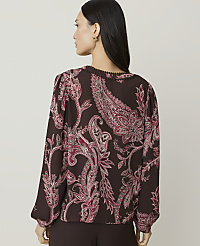 A woman in a brown paisley blouse stands against a plain background. carousel Product Image 2