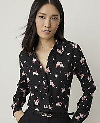 A woman with dark hair and fair skin wears a black floral-print blouse and black pants, with a plain background. carousel Product Image 1