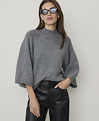 A woman in a grey sweater and black leather pants poses against a plain background. carousel Product Image 1
