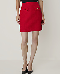 A woman in a red shirt and skirt stands against a plain background, holding a brown handbag. carousel Product Image 5