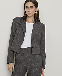 A woman in a plaid blazer and pants stands against a plain, light-colored wall. carousel Product Image 5