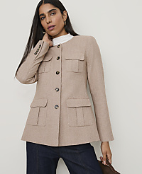 A woman in a tan jacket and dark jeans stands against a plain background. carousel Product Image 1