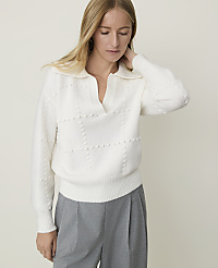 A woman in a white collared sweater and gray pants stands against a plain, light background. carousel Product Image 1
