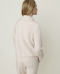 A woman in a light pink sweater and pants stands with her back to the camera against a plain, light-colored background. carousel Product Image 2