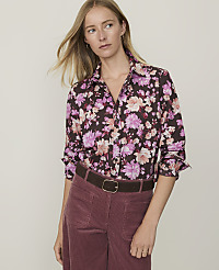 A woman in a floral shirt and maroon corduroy pants stands against a plain, light-colored background. carousel Product Image 1