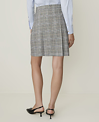 A woman in a plaid skirt and black loafers stands against a plain, light-colored background. carousel Product Image 3