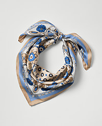 A patterned silk scarf with blue and tan floral designs is tied in a knot against a plain white background. carousel Product Image 1