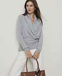 A woman in a gray sweater and white pants holds a brown tote bag in front of a plain background. carousel Product Image 1