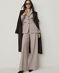 A woman in a beige suit and brown trench coat stands against a plain white background. carousel Product Image 4