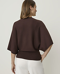 A woman in a brown sweater and white pants stands against a plain white background. carousel Product Image 2
