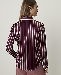 A woman in a burgundy and pink striped satin shirt stands against a plain, light-colored background. carousel Product Image 2