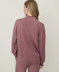 A woman in a rose-colored sweatshirt and pants stands against a plain, light-colored background. carousel Product Image 2