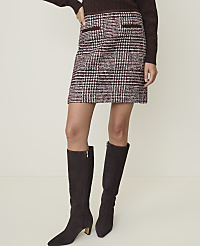 A woman models a tweed mini skirt and dark brown knee-high boots against a plain, light background. carousel Product Image 2