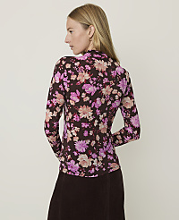 A woman in a floral top and brown skirt stands against a plain, light background. carousel Product Image 2