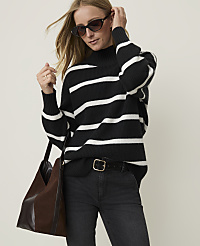 A woman in a striped sweater and sunglasses stands against a plain background, holding a brown bag. carousel Product Image 1