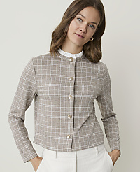 A woman in a plaid jacket and white pants stands against a plain background. carousel Product Image 1