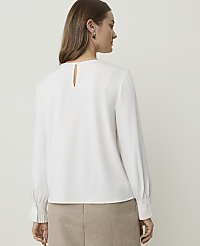 A woman in a white blouse and tan skirt stands against a plain, light-colored background. carousel Product Image 2