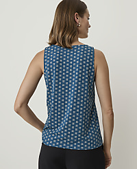 A woman in a teal patterned sleeveless top stands with her back to the viewer against a plain, light background. carousel Product Image 2