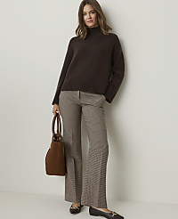 A woman in a brown turtleneck sweater and plaid pants stands with a brown handbag against a plain white background. carousel Product Image 4