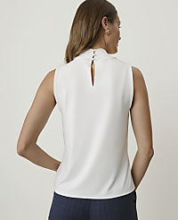 A woman in a white sleeveless top and blue shorts stands against a plain white background. carousel Product Image 2