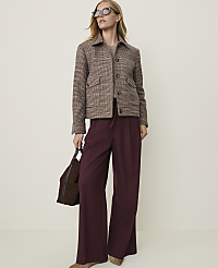 A woman in a brown plaid jacket and burgundy wide-leg pants stands against a plain, light-colored background, holding a dark brown handbag. carousel Product Image 1