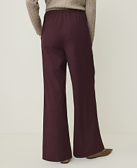 A person wearing burgundy flared pants and a beige sweater stands against a plain, light-colored background. carousel Product Image 3