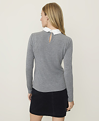 A woman in a gray sweater with a white collar and a dark skirt stands against a plain, light-colored background. carousel Product Image 2