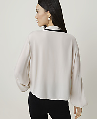 A woman in a cream blouse and black pants stands against a plain, light background. carousel Product Image 2