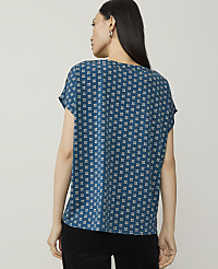 A woman in a patterned teal shirt stands against a plain white background. carousel Product Image 2