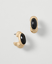 A pair of gold hoop earrings with black oval stones are displayed against a plain, light gray background. carousel Product Image 1