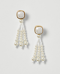 A pair of elegant pearl drop earrings with gold-toned square tops hang against a plain white background. carousel Product Image 1