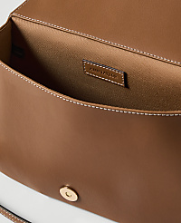 A brown leather clutch with a gold clasp is open, revealing its satin interior and a brand tag, against a plain white background. carousel Product Image 2