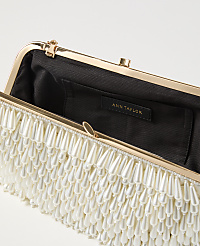 A white beaded clutch with a gold frame is open, revealing a black interior with an Ann Taylor tag, against a plain white background. carousel Product Image 2