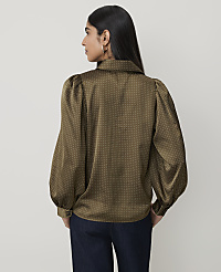 A woman in a polka-dot blouse stands against a plain background. carousel Product Image 2