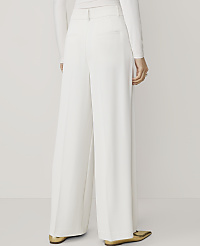 A person wearing white wide-leg pants and gold pointed-toe flats stands against a plain white background. carousel Product Image 3