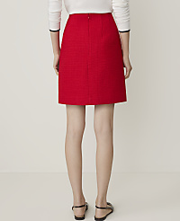A woman in a red tweed skirt and black heels walks away from the camera against a plain white background. carousel Product Image 4