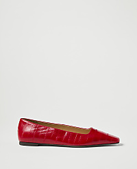 A red, pointed-toe ballet flat with a textured finish rests on a plain white background. carousel Product Image 1