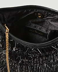 A black sequined clutch with a gold chain strap is shown against a dark, blurred background. carousel Product Image 2