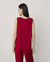 A woman in a red sleeveless top and pants stands against a plain, light gray background. carousel Product Image 2