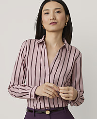 A woman in a pink and black striped blouse and purple pants stands against a plain, light gray background. carousel Product Image 1