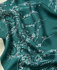 A teal fabric with a white floral paisley pattern is draped over a light-colored surface. carousel Product Image 2