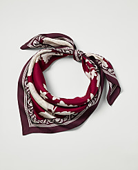 A burgundy and cream patterned silk scarf is tied in a knot against a plain white background. carousel Product Image 1