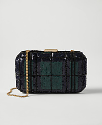 A rectangular clutch purse with a plaid pattern of navy blue and green sequins rests on a white surface, with a gold chain strap draped to the left. carousel Product Image 1
