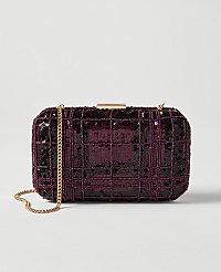 A rectangular, plum-colored sequined clutch with a gold chain strap rests on a plain white background. carousel Product Image 1