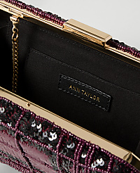A close-up of an open, sequined clutch with a gold clasp and chain, revealing the Ann Taylor brand tag inside against a dark fabric lining. carousel Product Image 2