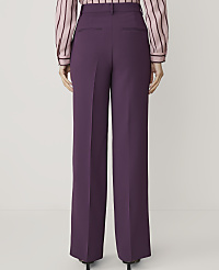 A person wearing purple wide-leg trousers and a striped pink and black blouse stands against a plain white background. carousel Product Image 3