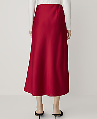A person wearing a red satin midi skirt and a white long-sleeved top stands against a plain white background. carousel Product Image 3