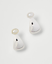 A pair of shiny, silver, bell-shaped earrings with pearl accents rest on a plain white background. carousel Product Image 1